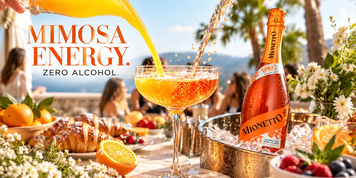Mionetto Alcohol Free Spritz served as a bright zero-alcohol mimosa with orange juice at a sunny brunch table with croissants, fresh fruit, flowers and ice.
