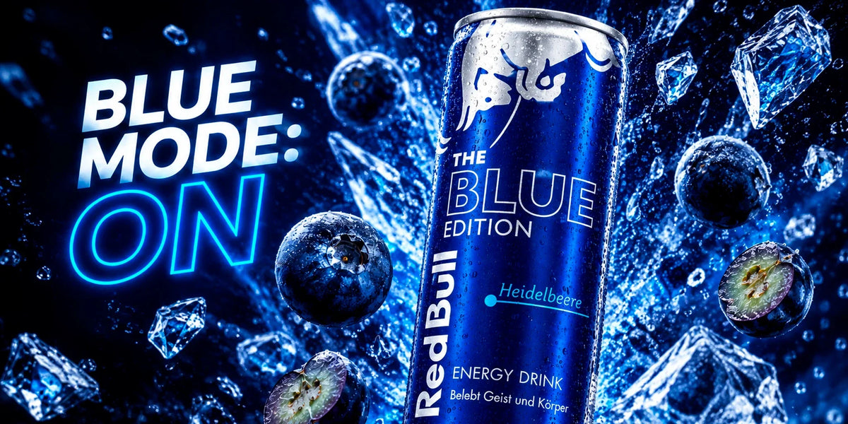 Red Bull The Blue Edition Blueberry energy drink can surrounded by blueberries, ice crystals and dramatic blue splash effects in a vibrant high-energy product scene.